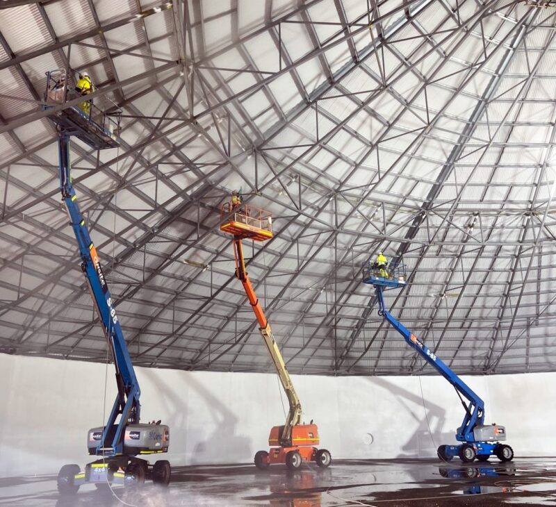 Man operating a scissor lift on a job site